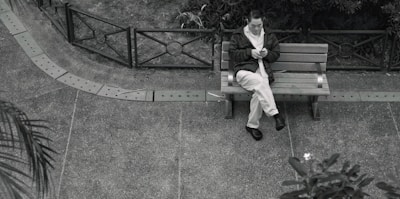 A person playing a mobile game on a park bench.