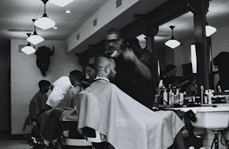 grayscale photography of man having haircur