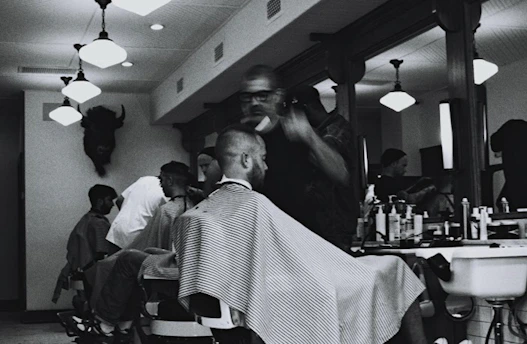 grayscale photography of man having haircur