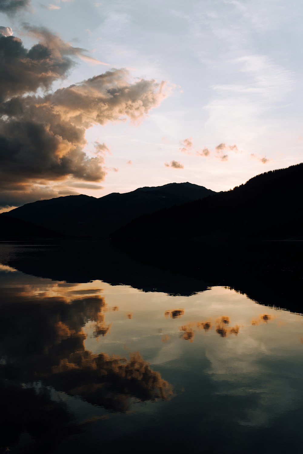 silhouette photography of mountain and body of water