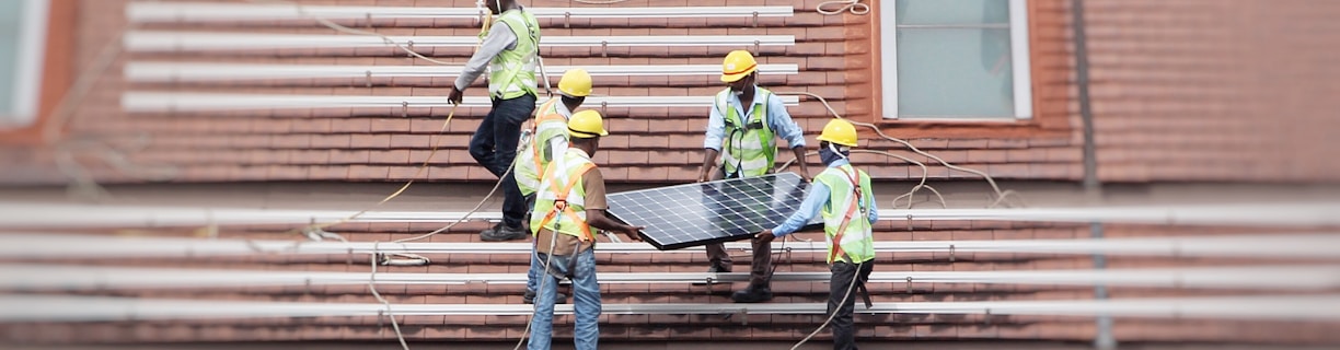man holding solar panel on roof