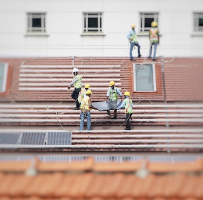 man holding solar panel on roof