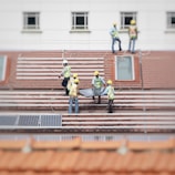 man holding solar panel on roof