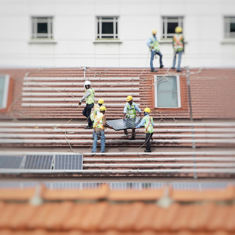 hombre sosteniendo un panel solar en el techo