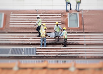 man holding solar panel on roof