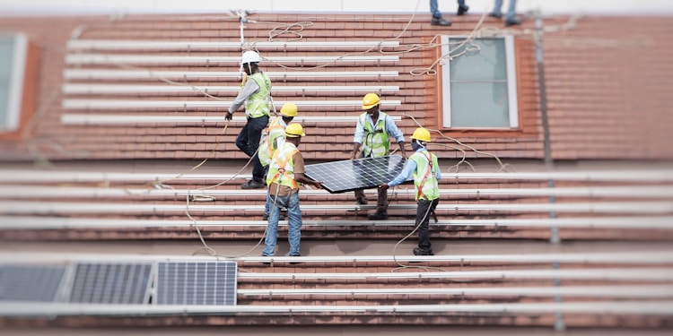 man holding solar panel on roof