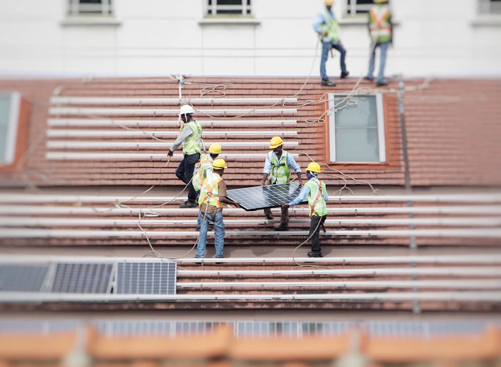 man holding solar panel on roof
