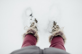 A pair of rugged winter boots on a snowy path.