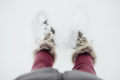A pair of rugged winter boots on a snowy path.