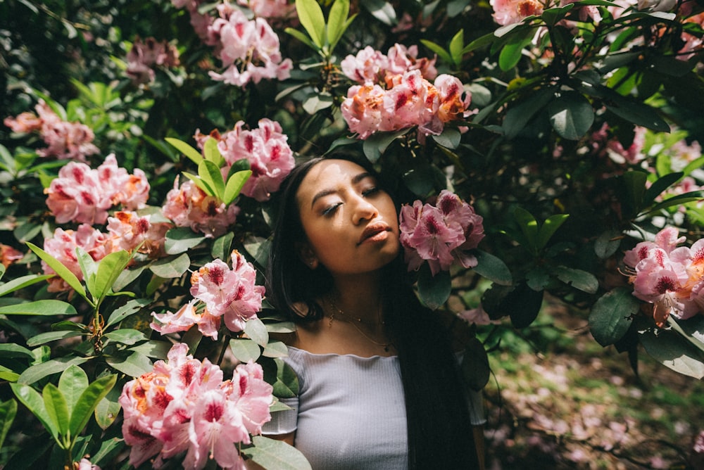 woman leaning on pink flowers