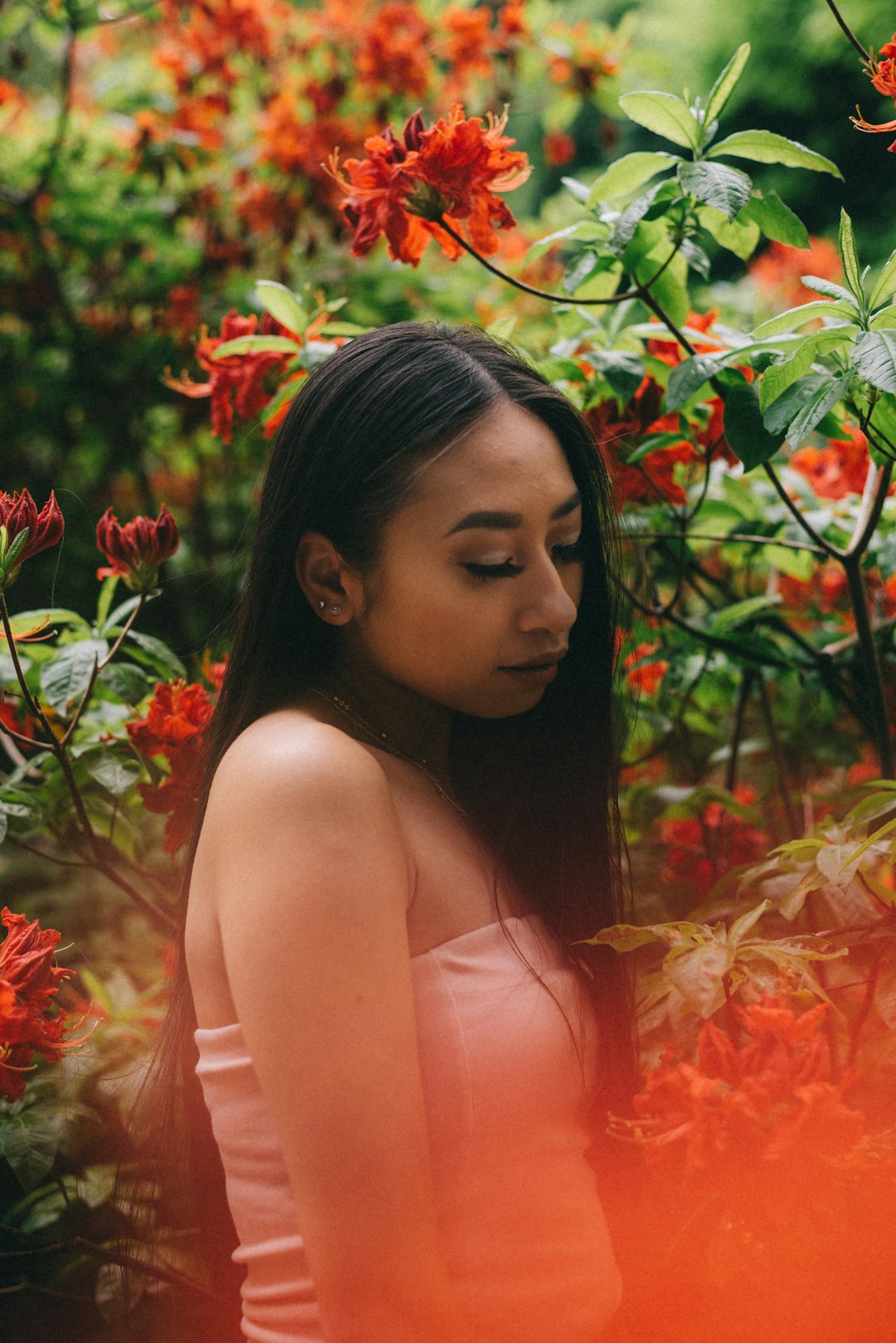 woman standing in front of red flowers