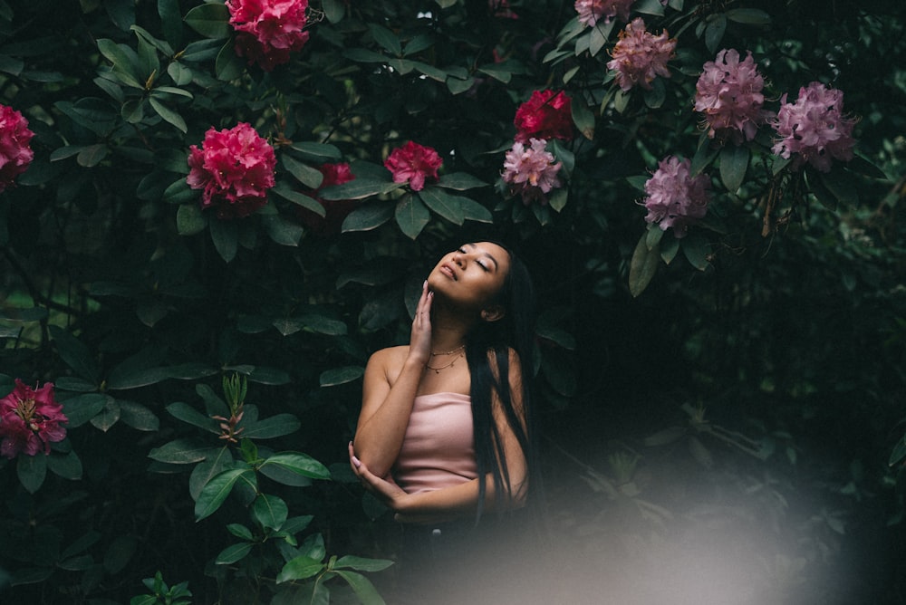 Frau steht unter lila und rosa Blumen