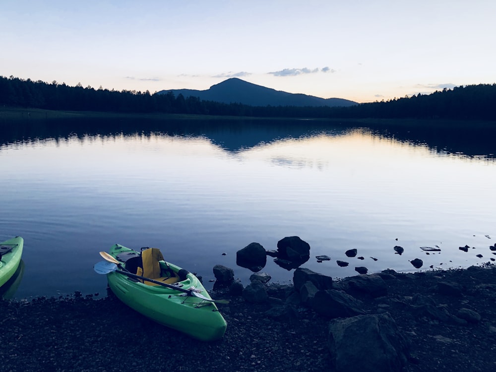 empty green kayak on lake