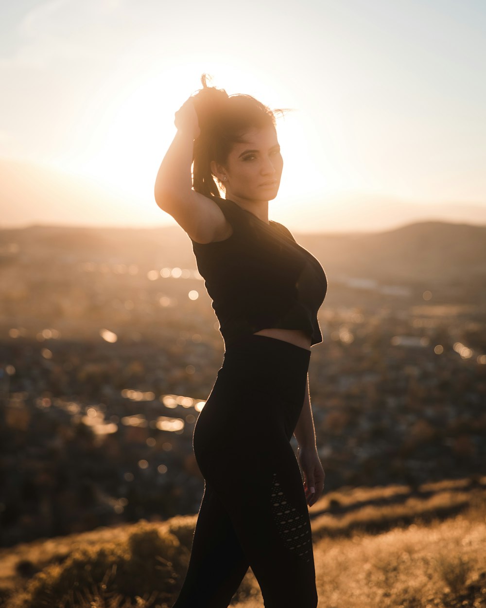 woman standing on top of mountain during golden hour