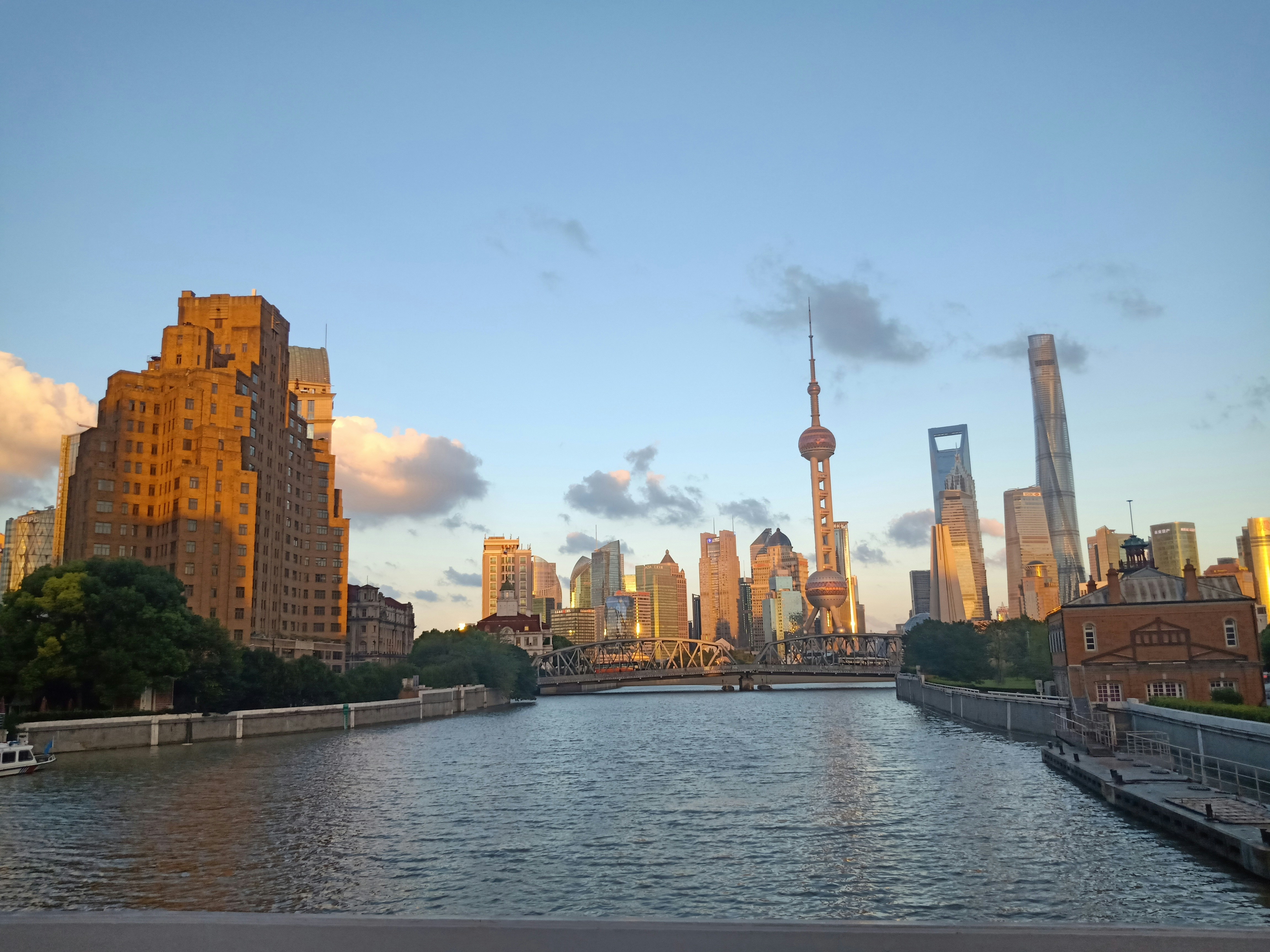 Aerial photograph of Shanghai rooftops at golden hour with misty skyline in background