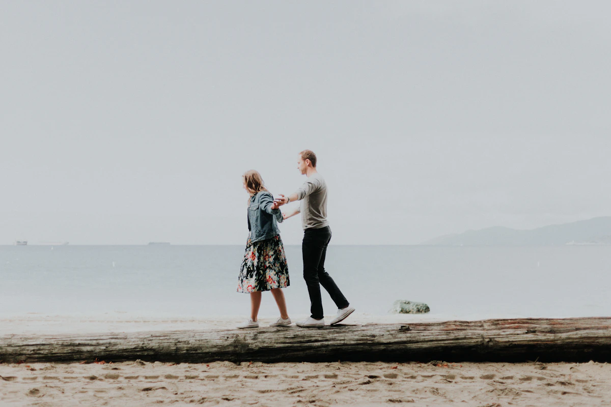 woman and man walking by the beach