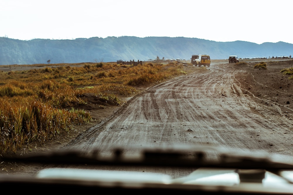 Dos vehículos en la carretera viendo el campo marrón