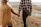 Happy couple walking hand-in-hand along a rustic farmhouse driveway surrounded by fields