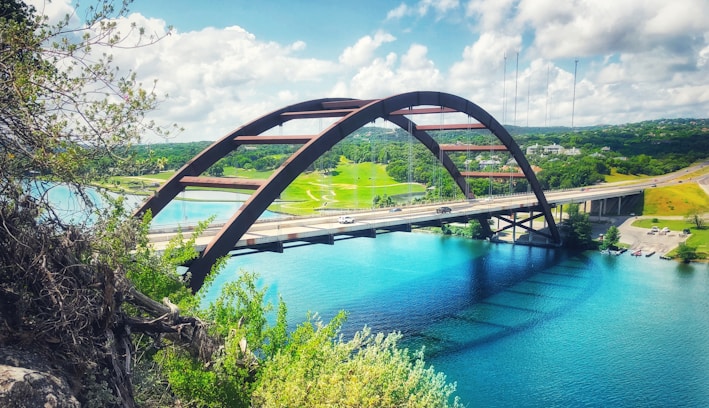 concrete bridge above calm body of water