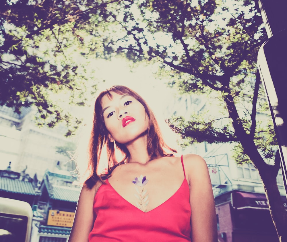 woman under trees near buildings