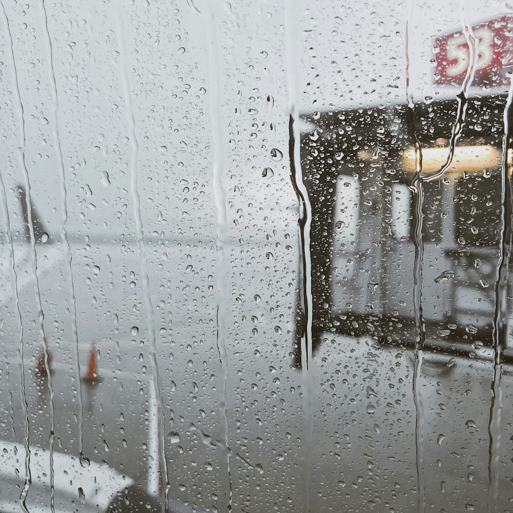 a window with rain drops on it and a building in the background