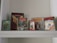 Several retro video game boxes are displayed on a shelf. The collection includes titles such as World Cup Football, Star Wars, Impossible Mission II, Tetris, and Ghostbusters. The games appear to be for older gaming systems, indicated by the distinctive box designs and logos.