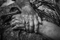 A warm, inviting scene of intertwined hands resting gently on soft fabric.