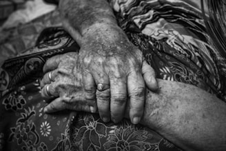 A warm, inviting scene of intertwined hands resting gently on soft fabric.