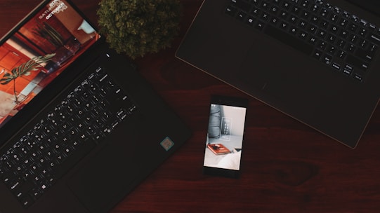 powered-on Android smartphone near two laptops