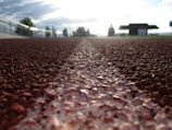 Construction workers installing a synthetic track surface.