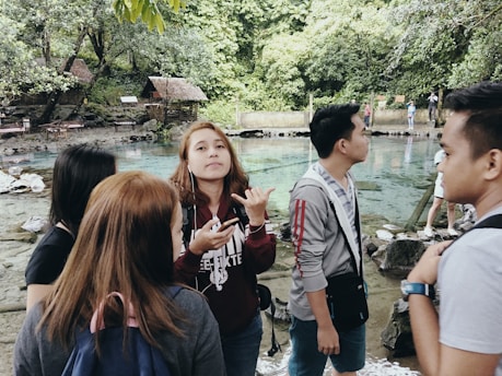 A group of happy hikers drinking mineral water by a natural spring in Stuttgart.