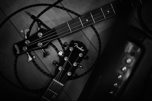 An array of guitar headstocks from different brands lined up on a rustic table.