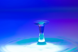 A sleek water droplet with glowing aqua blue waves flowing around it.