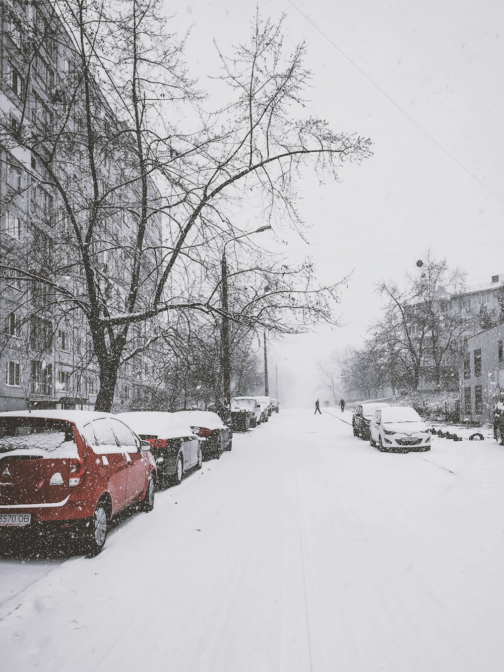 snow covered vehicle parked on sidewalk during daytime