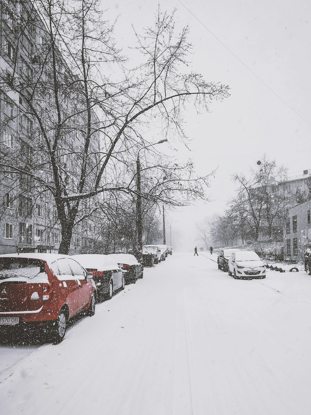 日中に歩道に駐車した雪に覆われた車両