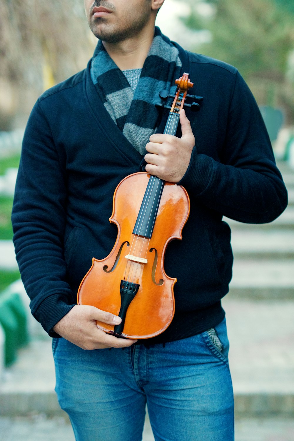 homem segurando violino marrom