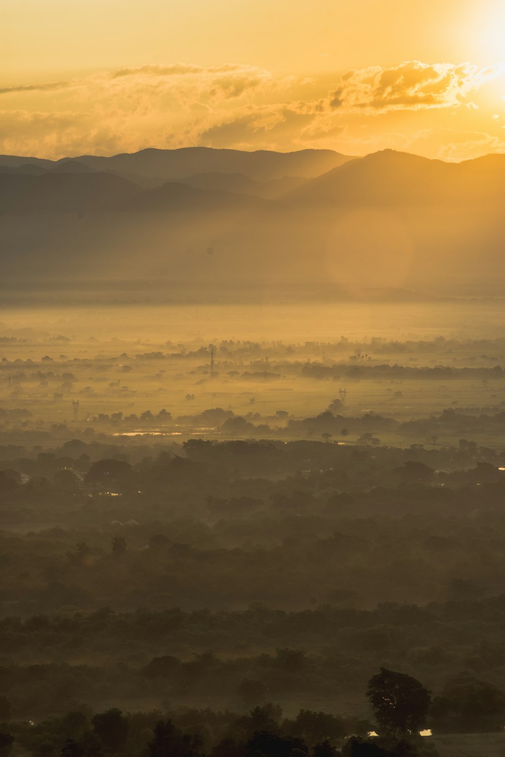 the sun is setting over a valley with hills in the distance