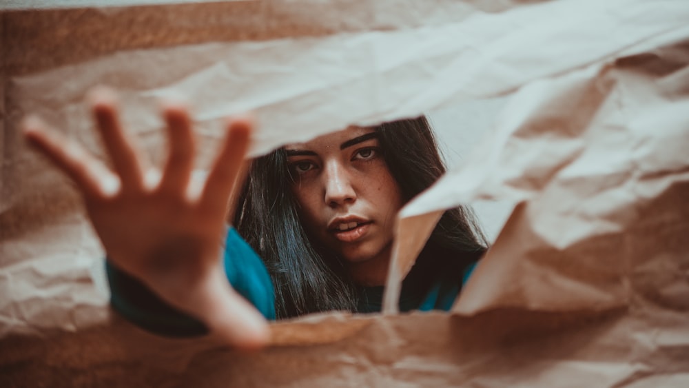 woman putting her hands on brown cardboard