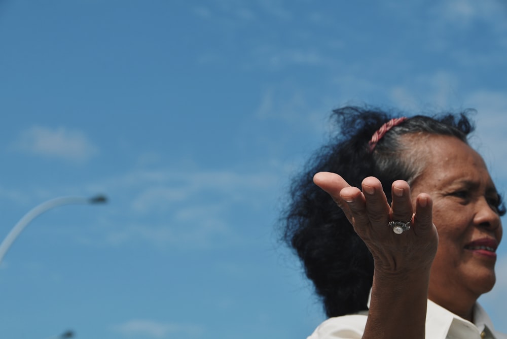 woman wearing white collared shirt under blue sky during daytime