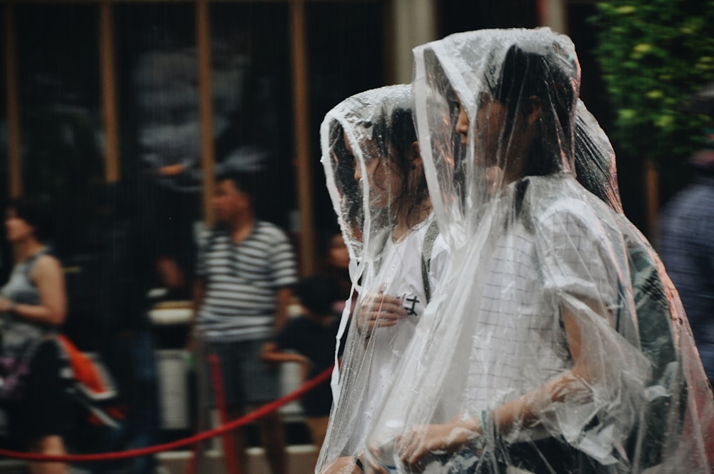 two women wearing white raincoats