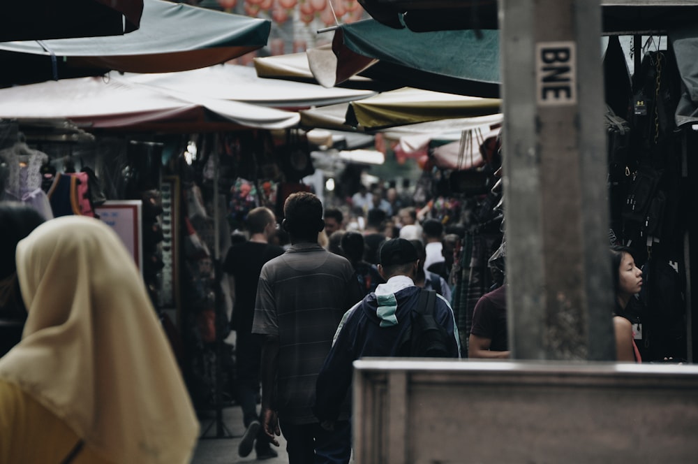 people walking on street passing stalls