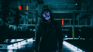 standing man in black jacket with mask