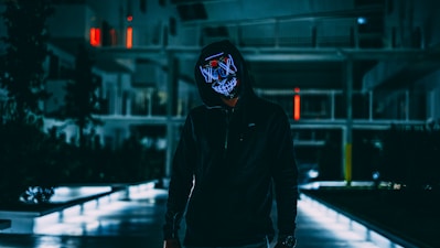 standing man in black jacket with mask