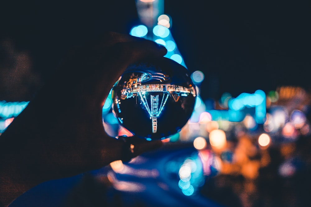 macro photography of person holding glass ball