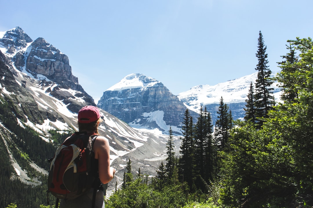 man standing near mountains\, Exploring Banff national park lead us to the very famous Lake Louise where we then decided