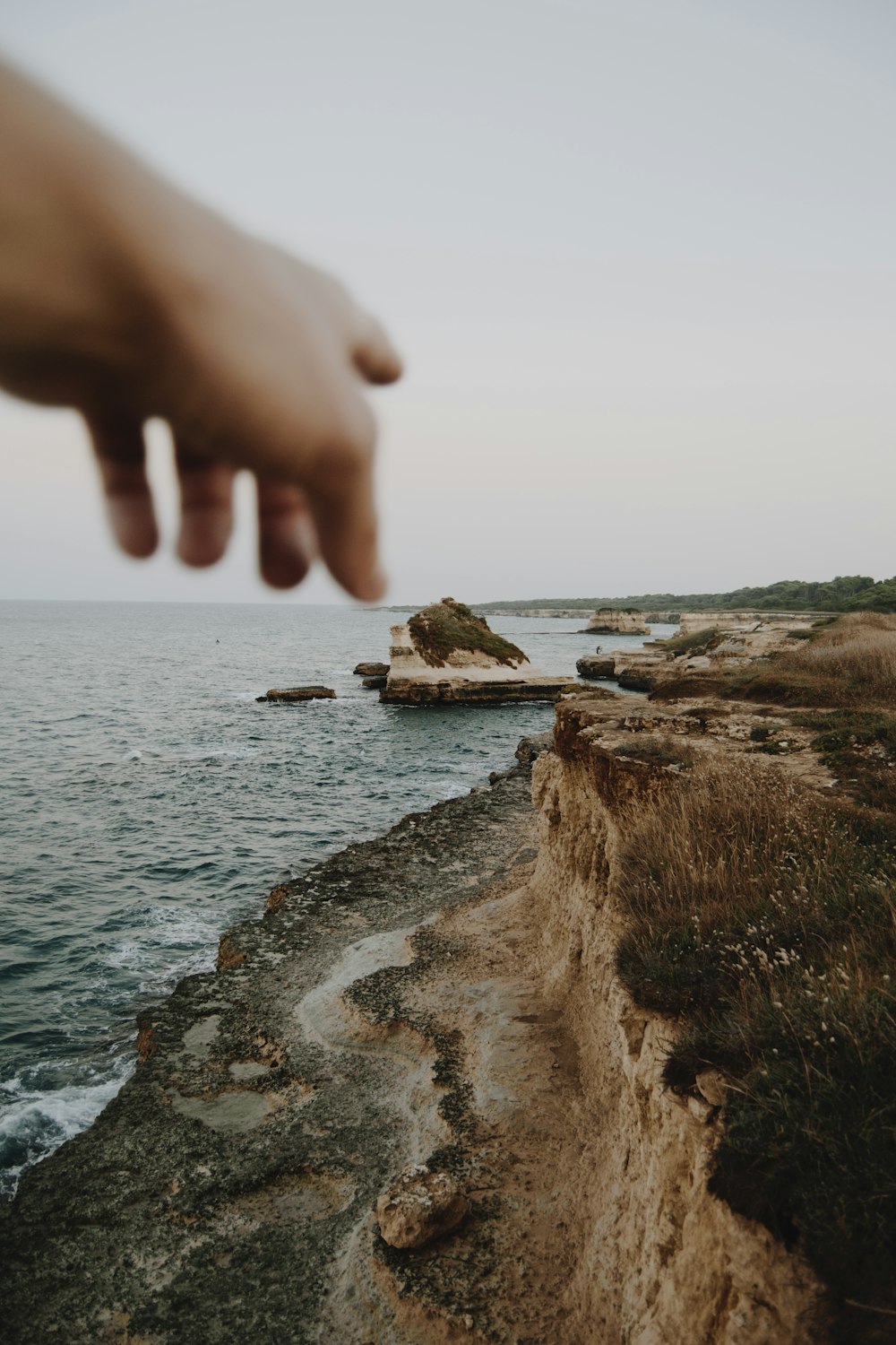 person pointing seashore