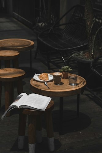 A stack of books with a cup of coffee on a reading nook table