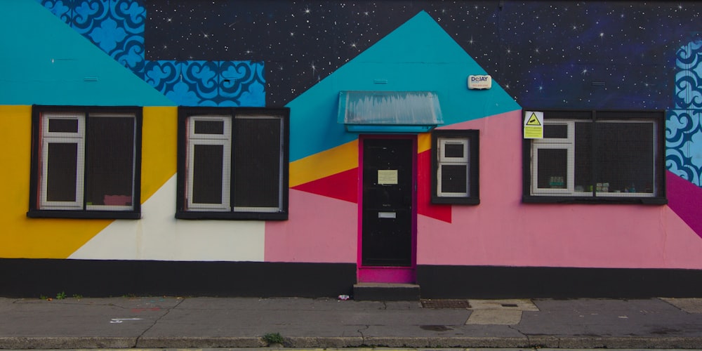 a colorful building with a black door and windows