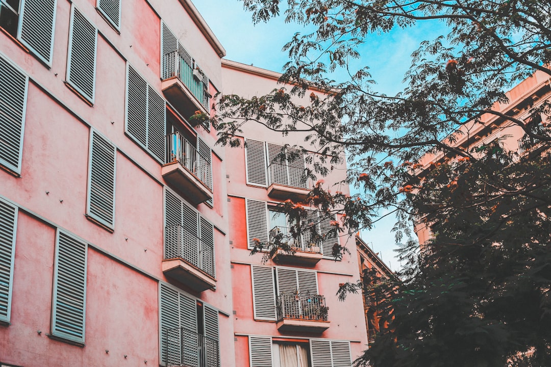 low-angle photography of pink concrete apartment during daytime