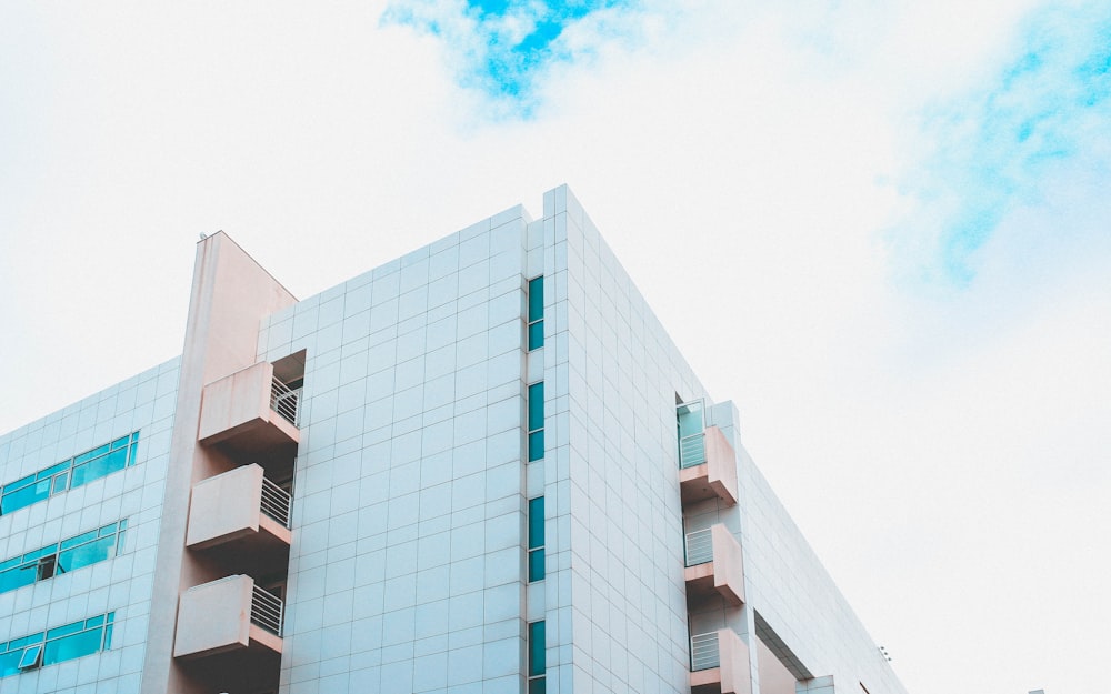 Photographie en contre-plongée d’un bâtiment en béton blanc et brun pendant la journée